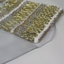Gold and white plastic and woven clutch detail