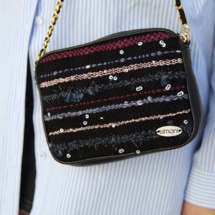 Black woven shoulder bag with burgundy, pink and blue stripes