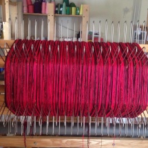 Red and black yarns on the loom